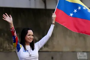 A líder da oposição da Venezuela, Maria Corina Machado, agita uma bandeira nacional durante protesto convocado pela oposição na véspera da posse presidencial, em Caracas (Foto: Juan Barreto - 9.jan.2025/AFP)