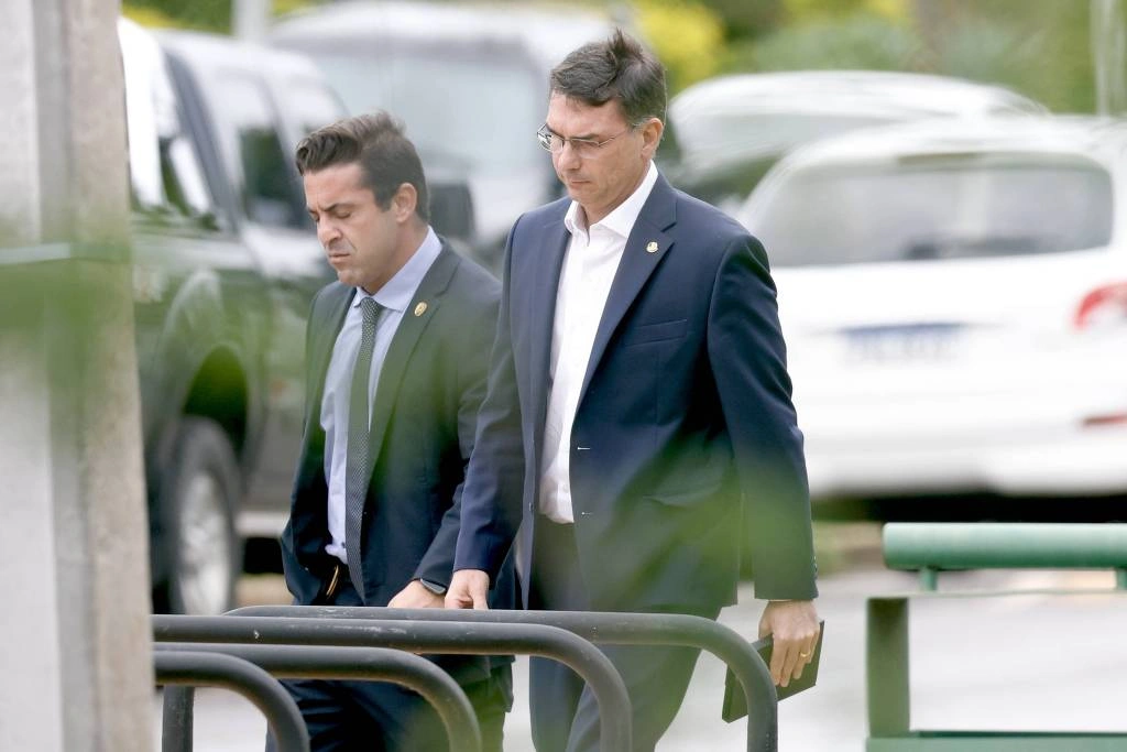 Flávio Bolsonaro (à dir.) ao deixar a sede da Superintendência da PF em Brasília, onde o pai está preso