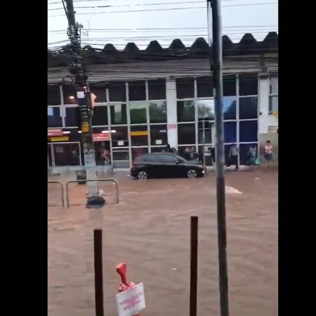 Rua totalmente alagada em frente à estação de trem de Santo André, no ABC paulista, na tarde deste sábado (19)