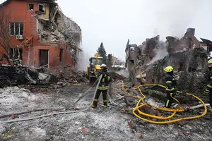 Bombeiros apagam um incêndio após um drone ter atingido um edifício residencial durante ataque aéreo russo em Kiev - 22 de fevereiro de 2026 (Foto: Reprodução | AP Photo)