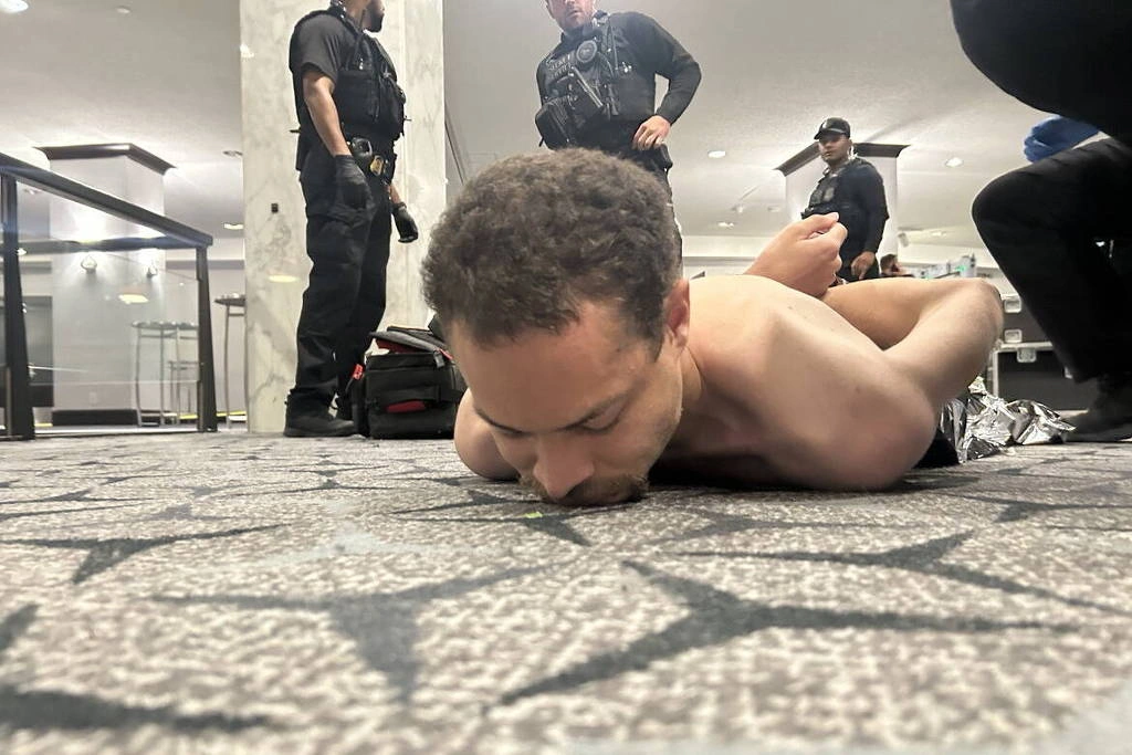 Fotografia divulgada por Donald Trump mostra atirador detido em hotel por agentes do Serviço Secreto neste sábado (25), após disparos em jantar com o presidente em Washington
