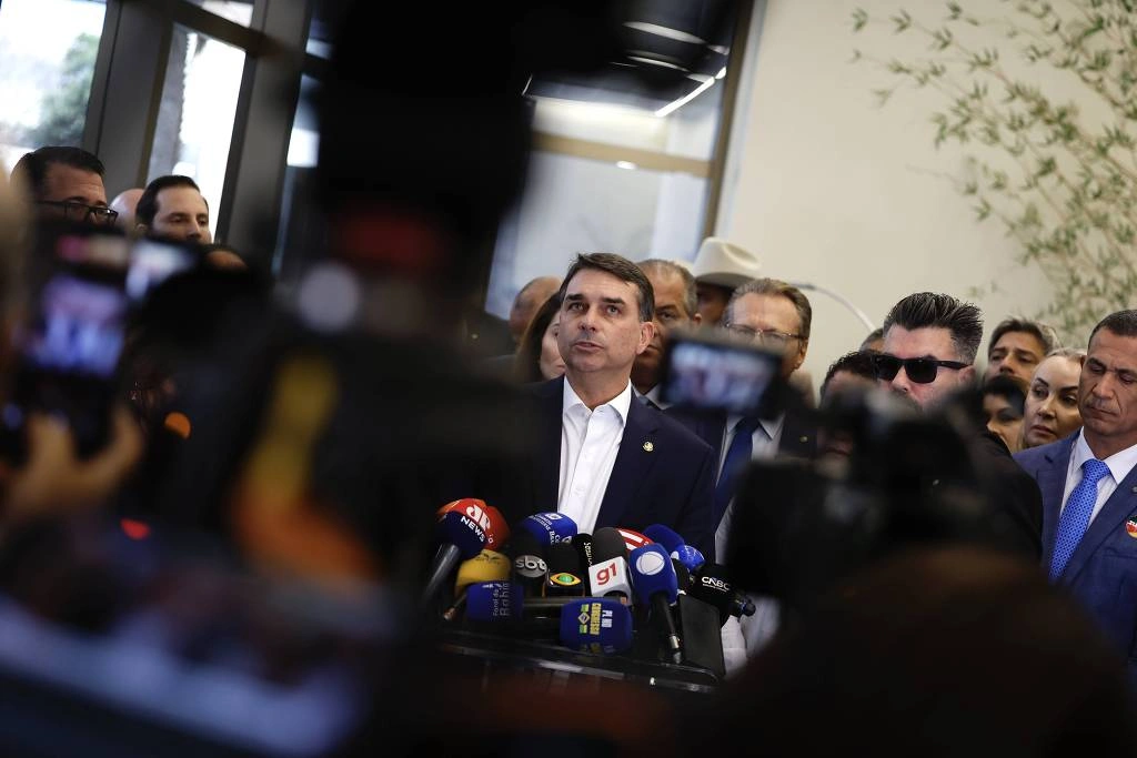 O senador Flávio Bolsonaro, acompanhado de integrantes da bancada do PL na Câmara e no Senado, faz uma declaração à imprensa após reunião do partido sobre o caso "Dark Horse"