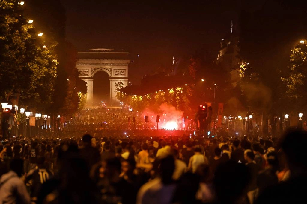 Torcedores do PSG se reúnem na avenida Champs-Élysées, em Paris, após a vitória do clube