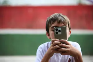 Criança usando o aparelho celular (Foto: Reprodução | Zanone Fraissat/Folhapress)